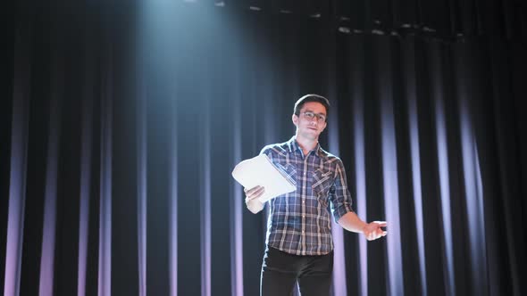 Stand Up Comedian on Stage. Young Man Talks Joke Into Microphone or Sings Songs
