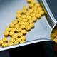 Selective focus on yellow tablets pills on stainless tray with blur hand of pharmacist or pharmacy  - PhotoDune Item for Sale
