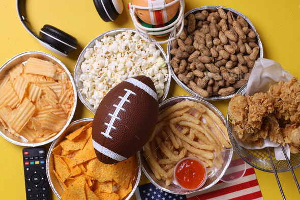 Top view of snacks for watching a football game. Super Bowl or Playoff concept on yellow background. - Stock Photo - Images