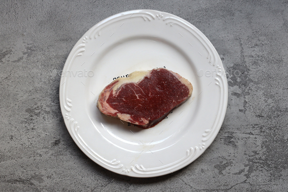Raw beef meat with on white plate - Stock Photo - Images