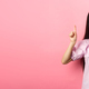 Smiling teen girl asian pointing fingers up at empty space, advertising on pink background - PhotoDune Item for Sale