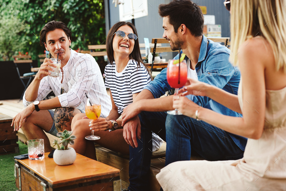 Group of young people drinking cocktails at a summer bar during the day ...