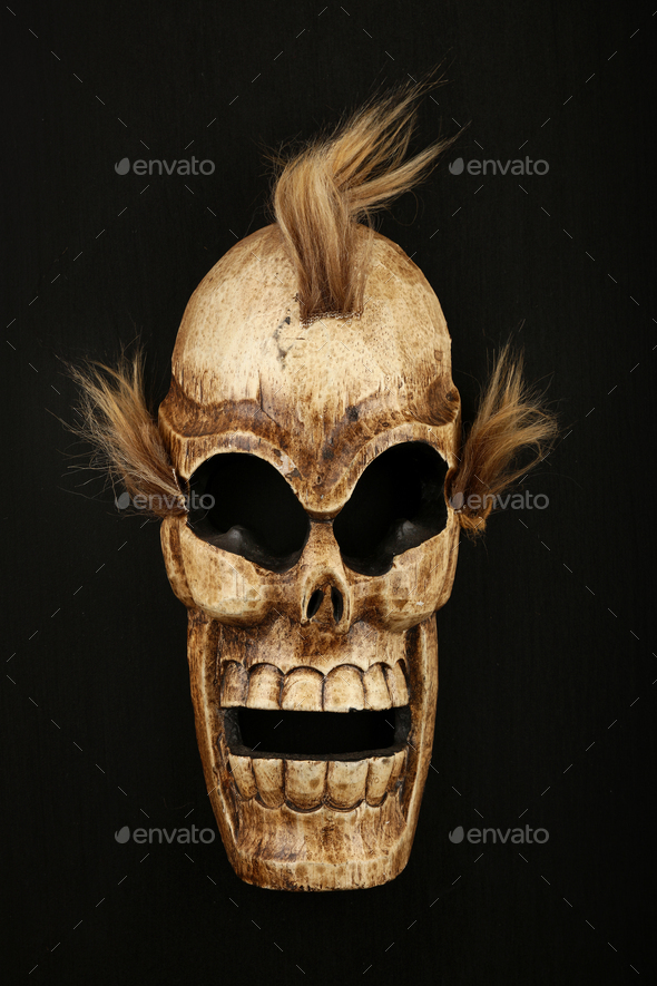 Wooden carved skull death mask on black