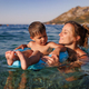 Caring mother rides her son on an inflatable ring in the sea - PhotoDune Item for Sale