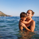 Cheerful mother plays with her son in the sea - PhotoDune Item for Sale