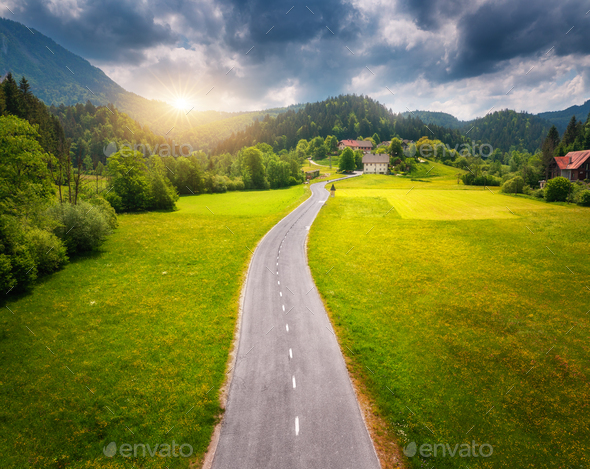 Aerial view of road in green meadows and hils at sunset in summer - Stock Photo - Images