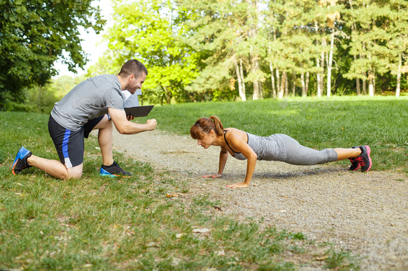 Man trainer motivates women to do push-ups