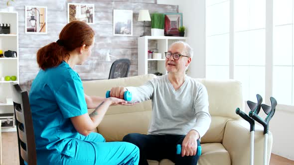 Muscle Rehabilitation Therapy - Nurse Is Helping a Disabled Old Man To Gain Strength alt