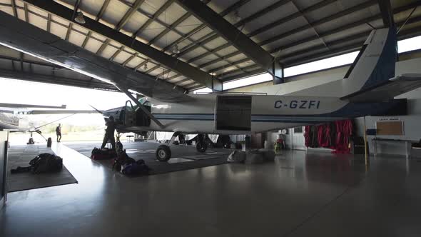 A white passenger plane parked in a small airplane hangar. alt