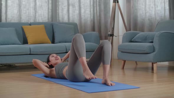 Asian Athletic Female In Sports Clothes Doing Crisscross Crunch Workout While Training At Home alt