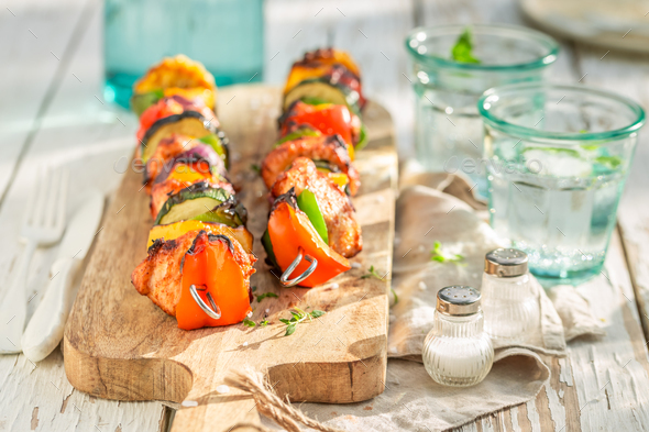 Spicy and fresh grilled skewers served with water in garden. - Stock Photo - Images