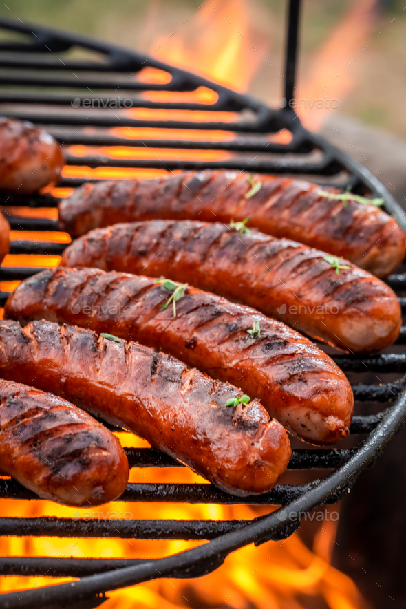 Hot and spicy sausage on grill fire in summer - Stock Photo - Images