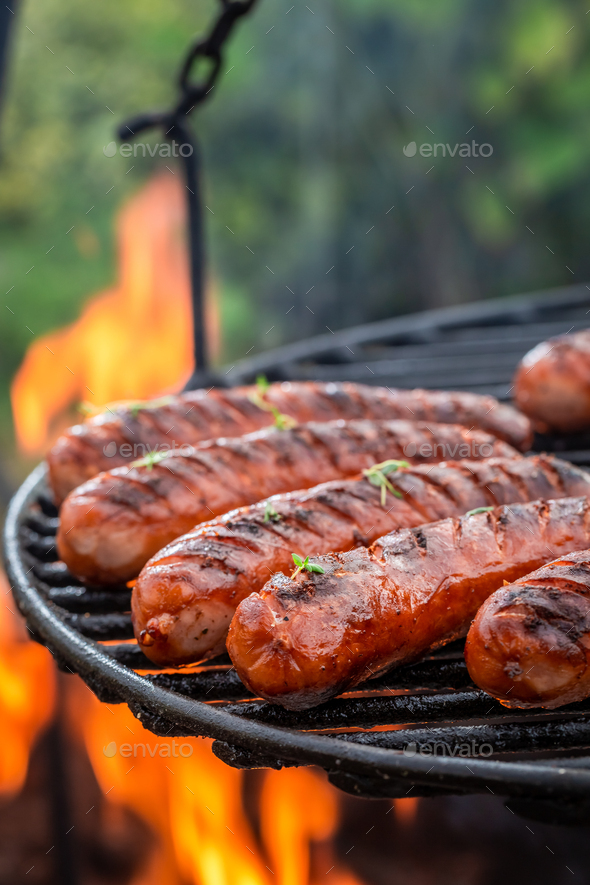 Spicy and hot sausage with herbs and spices on grill - Stock Photo - Images