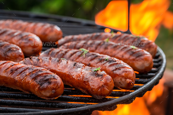 Hot sausage with spices on grill with fire in summer - Stock Photo - Images