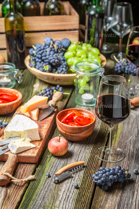 Supper on old wooden table with appetizers and wine - Stock Photo - Images