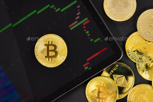 Bitcoin on digital tablet with exchange graph by crypto coins - Stock Photo - Images