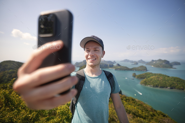 Man taking selfie against group of tropical islands - Stock Photo - Images