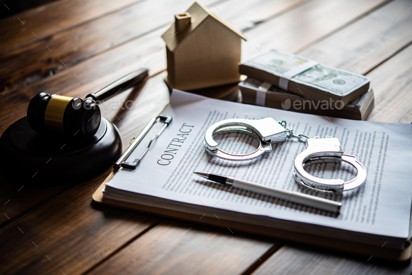 The handcuff is placed on a contract of sale. The concept is not fair to the contract. - Stock Photo - Images