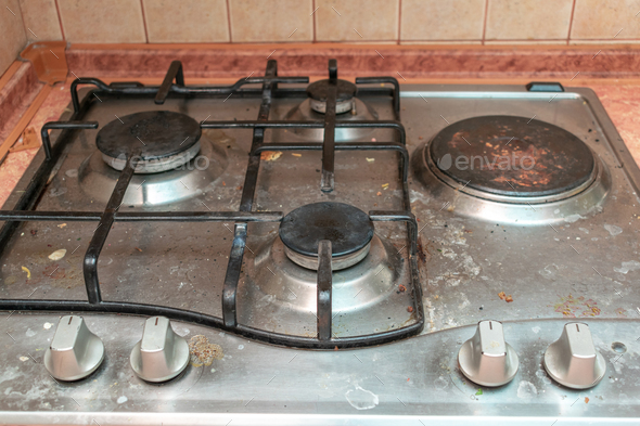 Dirty gas stove in grease stains burners in kitchen room