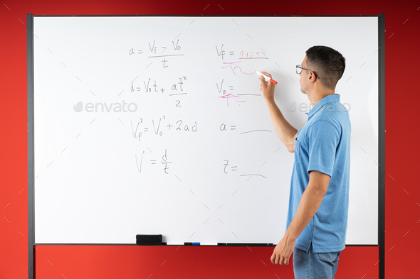 Male student doing math exercises on the white board, with a marker pen