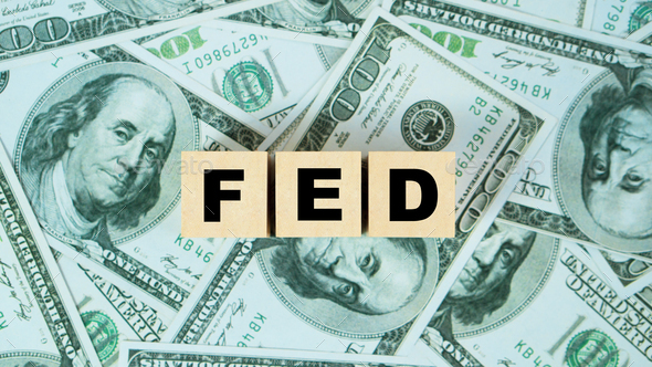 FED word on Wooden block with dollar backgound.The Federal Reserve to control interest rates.  - Stock Photo - Images