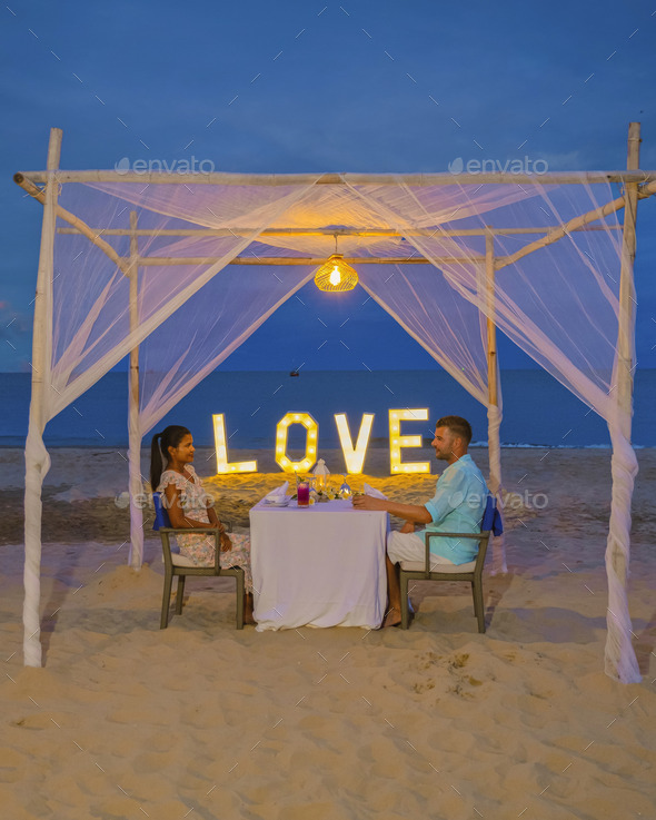 Romantic dinner on the beach in Phuket Thailand, couple man and woman having dinner on the beach - Stock Photo - Images