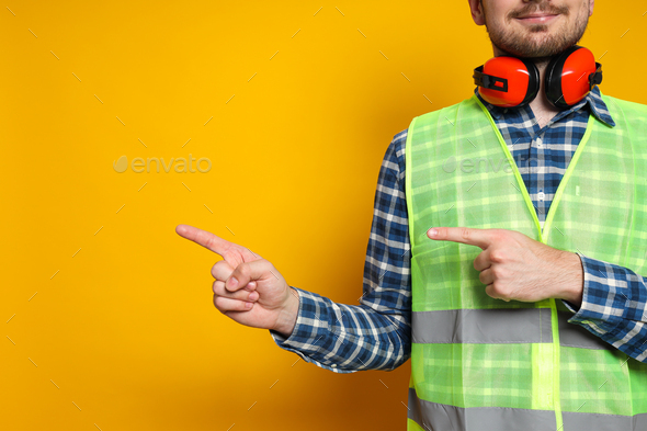 Young man civil engineer with ear protectors, space for text