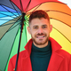 Portrait of latin young man with a red coat and a rainbow umbrella. - PhotoDune Item for Sale