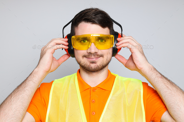 Young man civil engineer in ear protectors and goggles