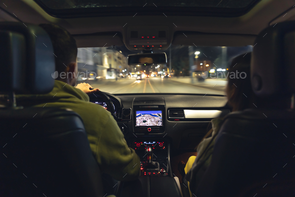 Man and woman in a car at night, view from the car. - Stock Photo - Images