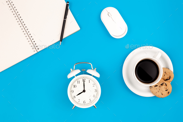 Alarm clock and coffee on blue background, work concept, flat lay. - Stock Photo - Images