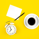 Alarm clock, cup of coffee and paper on a yellow background, flat lay. - PhotoDune Item for Sale