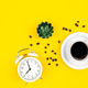 Alarm clock, cup of coffee and coffee beans on a yellow background, flat lay. - PhotoDune Item for Sale