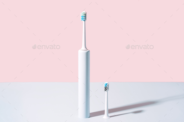 Electric toothbrush with brush head against blue-pink background - Stock Photo - Images