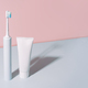 Electric toothbrush with toothpaste against a blue-pink background - PhotoDune Item for Sale