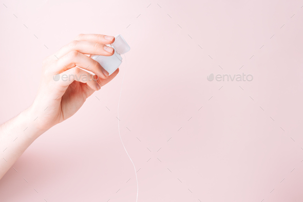 Dental floss in a female hand against a pink background - Stock Photo - Images