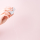 Dental floss in a female hand against a pink background - PhotoDune Item for Sale