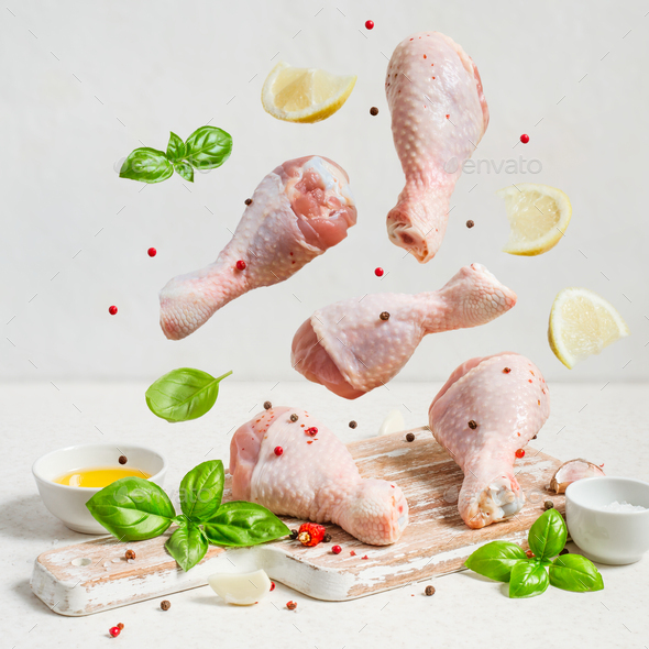 Raw chicken drumstick And spices fly over the cutting board