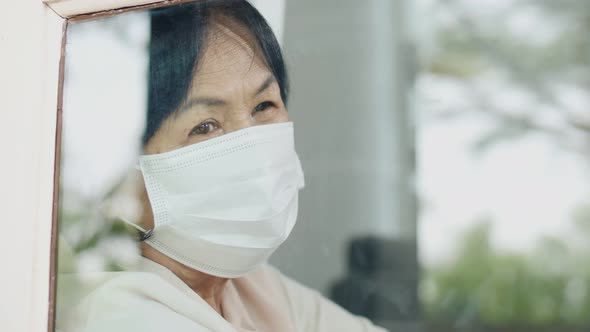 Slow motion shot Lonely Asian old woman looking outside the window, Stay  home for quarantine by RedcupStudio