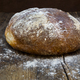 Wheat bread powdered with flour on dark wood - PhotoDune Item for Sale