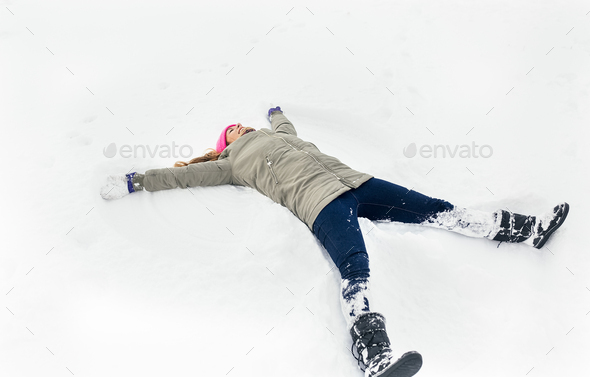 Young woman making a snow angel