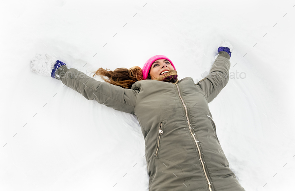 Young woman making a snow angel