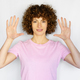 Adult woman with curly hair showing palms in studio - PhotoDune Item for Sale