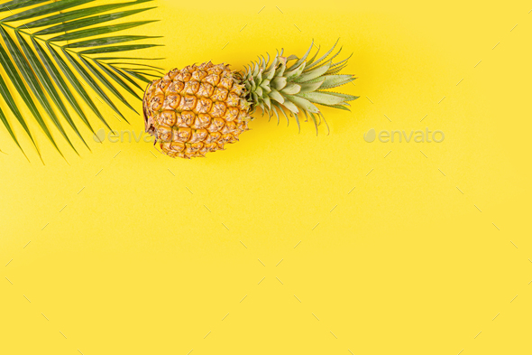 Pineapples and tropical palm leaves on yellow background. Top view, mockup, template, overhead - Stock Photo - Images