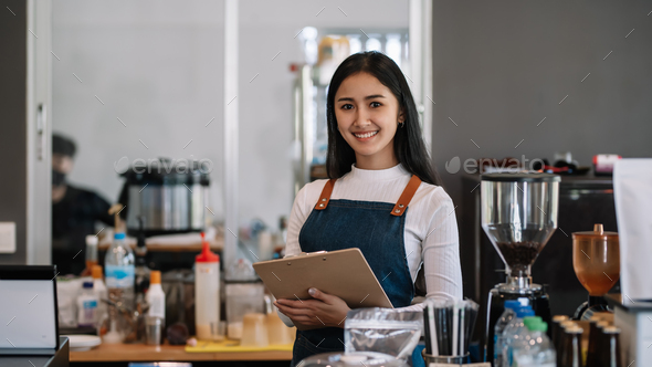 image of Asian female barista wearing an apron at the café owner taking ...