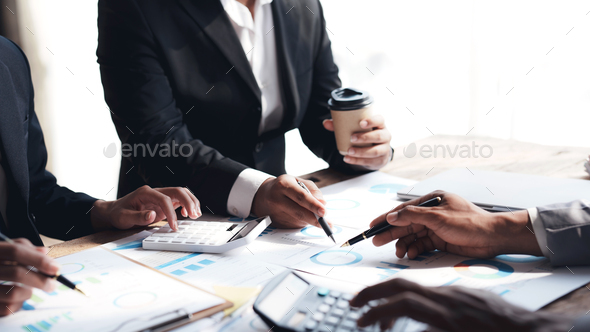 Meeting of business people pointing at graphs and charts to analyze market data, balance sheet, - Stock Photo - Images