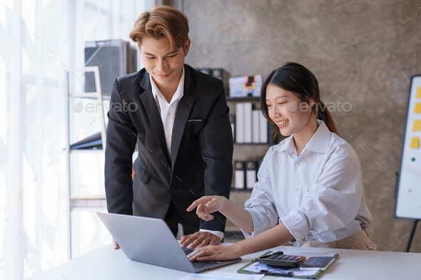 Two Asian business people are consulting on marketing planning, a new corporate sales strategy  - Stock Photo - Images