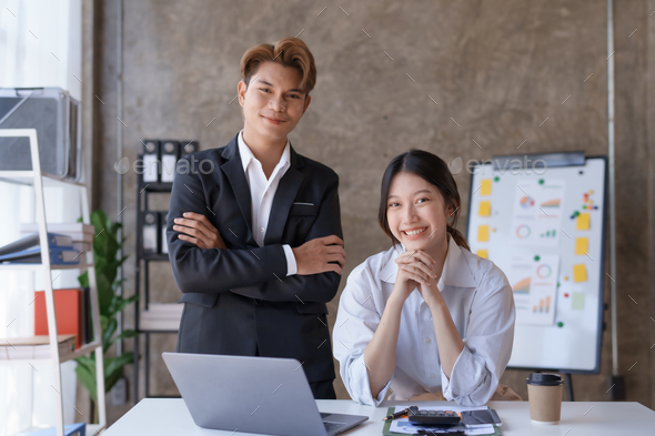 Two Asian business people are consulting on marketing planning, a new corporate sales strategy  - Stock Photo - Images