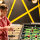 Boy playing table football in kids play center. - PhotoDune Item for Sale