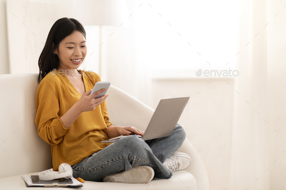 Positive japanese woman freelancer working from home, using